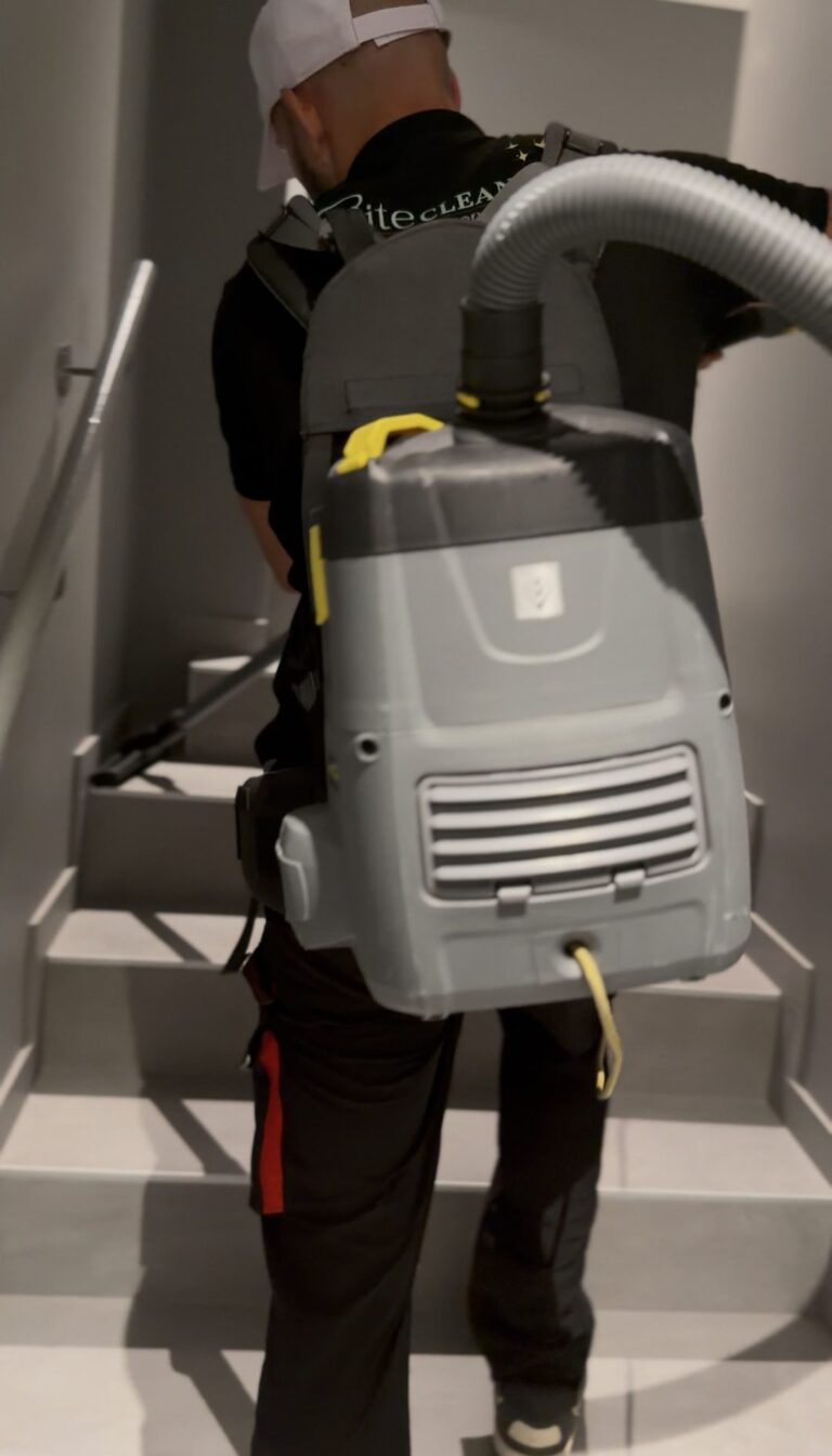 Entretien des escaliers d'un immeuble à l'aspirateur dorsal, service de conciergerie EliteCleanCo